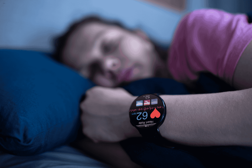 Mulher dormindo com smartwatch monitorando frequência cardíaca